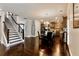 Open living area featuring a staircase, dining area, and kitchen with modern appliances and hardwood flooring at 133 Canal St, Hampton, GA 30228