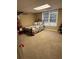 Basement bedroom features a bed, small shelving unit and a window at 1502 La Fayette Pl, Loganville, GA 30052