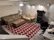 A cozy basement living area with plush couches, a red patterned rug, and a ceiling fan at 1502 La Fayette Pl, Loganville, GA 30052