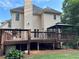 Rear of the beige two-story home featuring a stained wood deck and a backyard gazebo at 1502 La Fayette Pl, Loganville, GA 30052