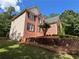 Two-story home featuring brick and vinyl siding, black shutters, and mature trees at 1502 La Fayette Pl, Loganville, GA 30052