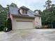 Beige two-story home features an attached two-car garage and a dormer window under a dark shingled roof at 1502 La Fayette Pl, Loganville, GA 30052