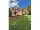 Brick two-story home boasts lush green lawn, tiered landscaping, black shutters and mature trees at 1502 La Fayette Pl, Loganville, GA 30052