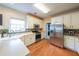 Bright eat-in kitchen features white cabinets, stainless appliances and tiled backsplash at 1996 Wellesley Trce, Atlanta, GA 30338