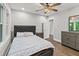 Bedroom with a window, ceiling fan, wood floors and a gray upholstered headboard at 2025 Venetian Sw Dr, Atlanta, GA 30311