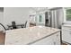 Kitchen island features a stone countertop with white cabinets and stainless steel refrigerator at 2025 Venetian Sw Dr, Atlanta, GA 30311