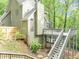 Multi-level home featuring a deck, with stairs, nestled among trees on a sloped lot at 284 Due West Ct, Dallas, GA 30157