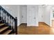 Elegant foyer with hardwood floors, a black staircase, and multiple white doors leading to various rooms at 284 Due West Ct, Dallas, GA 30157