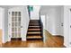 Welcoming foyer featuring hardwood floors, a dark-stained staircase, and a glass-paneled door to the left at 284 Due West Ct, Dallas, GA 30157