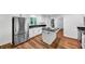Bright kitchen with white cabinets, stainless steel appliances, a granite countertop island, and wood-look flooring at 284 Due West Ct, Dallas, GA 30157