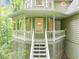 Close-up of a charming front porch featuring a railing, stairs, and cozy seating area surrounded by greenery at 284 Due West Ct, Dallas, GA 30157