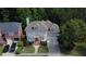 Aerial view of a gray home with a lush, green lawn and tree-lined street at 7520 Ledgewood Way, Suwanee, GA 30024