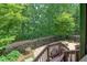 Stunning back yard features a stone patio with a fire pit surrounded by lush greenery and a fence at 7520 Ledgewood Way, Suwanee, GA 30024