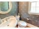 Elegant powder room with designer wallpaper, oval mirror, and pedestal sink at 7520 Ledgewood Way, Suwanee, GA 30024
