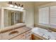 Relaxing bathroom featuring a jacuzzi tub and large vanity at 7520 Ledgewood Way, Suwanee, GA 30024
