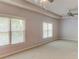 Sunlit bedroom showcasing dual windows and a ceiling fan for enhanced comfort at 7520 Ledgewood Way, Suwanee, GA 30024