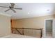 Bright bonus room with ceiling fan, neutral paint, and iron railing at 7520 Ledgewood Way, Suwanee, GA 30024