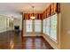 Open dining space showcasing hardwood floors, large windows, and fireplace beyond at 7520 Ledgewood Way, Suwanee, GA 30024