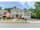 Charming two-story home with a bright red front door, balcony, landscaped yard, and convenient attached two-car garage at 7520 Ledgewood Way, Suwanee, GA 30024