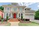 Stately home featuring a red front door, balcony, manicured lawn, beautiful flowerbeds and an attached two-car garage at 7520 Ledgewood Way, Suwanee, GA 30024