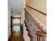 Welcoming hallway with hardwood floors, an elegant staircase with iron railings, and view into the living room at 7520 Ledgewood Way, Suwanee, GA 30024