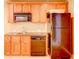 Kitchenette with wood cabinets, microwave, sink and stainless dishwasher, next to stainless fridge at 7520 Ledgewood Way, Suwanee, GA 30024
