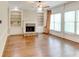Sun-filled living room with fireplace, built-in shelves, and hardwood floors at 7520 Ledgewood Way, Suwanee, GA 30024
