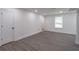 Finished basement area with gray flooring, white walls, recessed lights and bright window at 2265 Hillbriar Dr, Buford, GA 30518