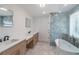 Bright bathroom with double vanity, quartz countertops, freestanding tub and tiled shower at 2265 Hillbriar Dr, Buford, GA 30518