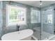 Bathroom featuring a modern freestanding tub, tiled walls and a glass-enclosed shower at 2265 Hillbriar Dr, Buford, GA 30518