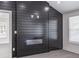 Modern electric fireplace with black shiplap accent wall, and gray flooring at 2265 Hillbriar Dr, Buford, GA 30518