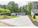 Modern farmhouse with a pristine lawn, long driveway and lush, mature trees at 2265 Hillbriar Dr, Buford, GA 30518