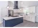 Modern kitchen featuring white cabinets, a navy island with cooktop, and stainless steel appliances at 2265 Hillbriar Dr, Buford, GA 30518