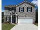 Two-story home featuring a gray brick facade, side of gray siding, and a two car garage at 2348 Argento Cir, Dacula, GA 30019