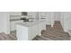 Modern kitchen featuring white cabinets, granite counters, an island, and wood-look flooring at 2348 Argento Cir, Dacula, GA 30019