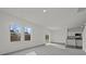 Open-concept living room with gray carpet, natural light, and a view to the kitchen with white cabinets at 2348 Argento Cir, Dacula, GA 30019
