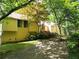 Charming yellow home featuring a cozy entrance, lovely landscaping, and a well-maintained front yard at 363 Weatherstone Ln, Marietta, GA 30068