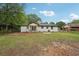 Expansive backyard view featuring a white-bricked house, fountain, and lush lawn at 1340 Juneau Ct, Tucker, GA 30084