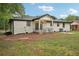 A well-maintained backyard featuring a white-bricked house, a fountain, and a covered porch at 1340 Juneau Ct, Tucker, GA 30084