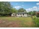A spacious backyard with a view of the home's exterior, mature trees, and lush lawn at 1340 Juneau Ct, Tucker, GA 30084