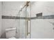 Bathroom featuring a glass shower with gold trim and marble-look tiles at 1340 Juneau Ct, Tucker, GA 30084