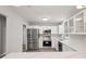 Modern kitchen featuring stainless steel appliances, white cabinetry and stone countertops, with open doorway at 1340 Juneau Ct, Tucker, GA 30084