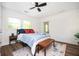 Bright bedroom featuring a queen bed, bench, and brick wall at 1678 Capistrana Pl, Decatur, GA 30032