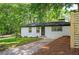 One-story painted brick home featuring updated landscaping, dark trim, and level driveway at 1678 Capistrana Pl, Decatur, GA 30032