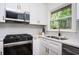 Modern kitchen features stainless steel appliances, white herringbone backsplash, and gold hardware at 1678 Capistrana Pl, Decatur, GA 30032