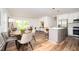 Open-concept living and kitchen area with hardwood floors, modern lighting, and island seating at 1678 Capistrana Pl, Decatur, GA 30032