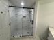 Modern bathroom featuring a stylish glass-enclosed shower with marble-patterned walls and geometric tile floor at 3050 Camden Way, Alpharetta, GA 30005