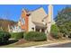 A charming townhome featuring a mix of brick and beige siding, complemented by mature landscaping at 3050 Camden Way, Alpharetta, GA 30005