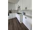 Modern kitchen features white cabinets, black hardware, white countertops, and stainless steel appliances at 3050 Camden Way, Alpharetta, GA 30005