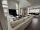 A bright living room features soaring windows, a comfortable L-shaped couch and a large TV at 3050 Camden Way, Alpharetta, GA 30005